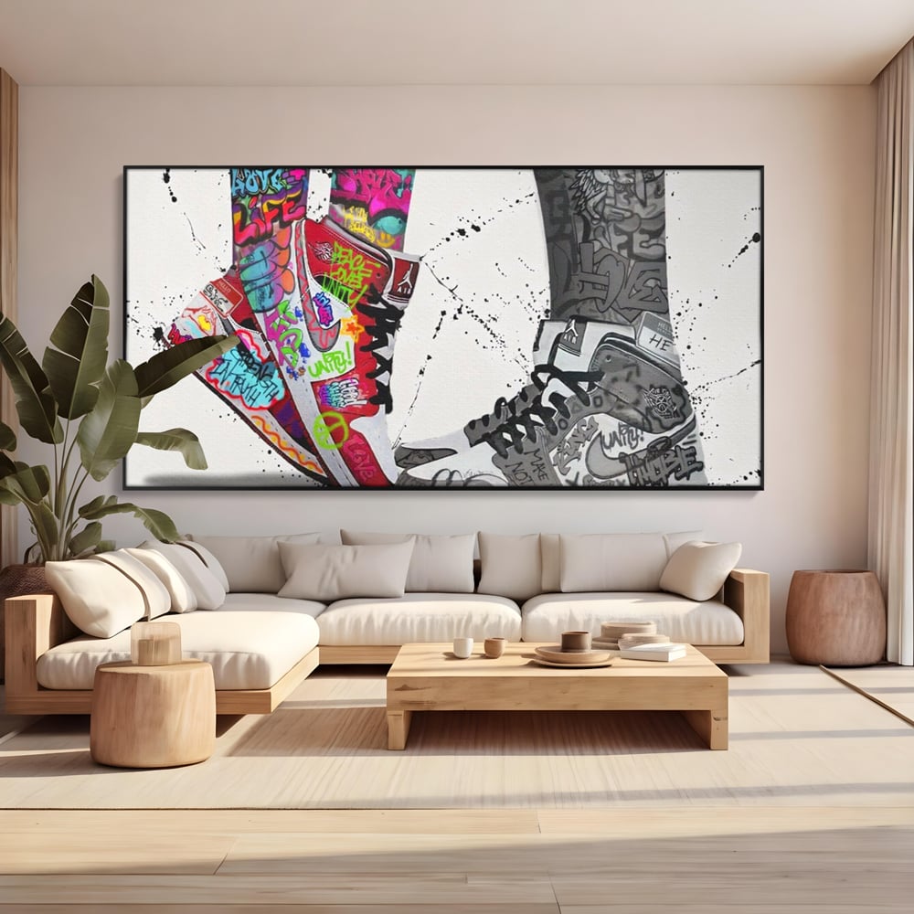 Tablou canvas cu tablou canvas cu adidasi graffiti si picioare, in rama de aluminiu negru, pe perete intr-un living